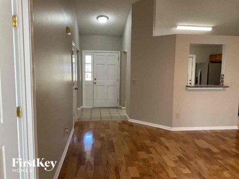 a living room with a wooden floor and a white door