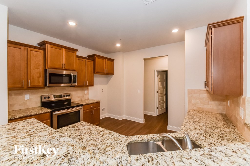 A kitchen with wooden cabinets and a granite countertop.