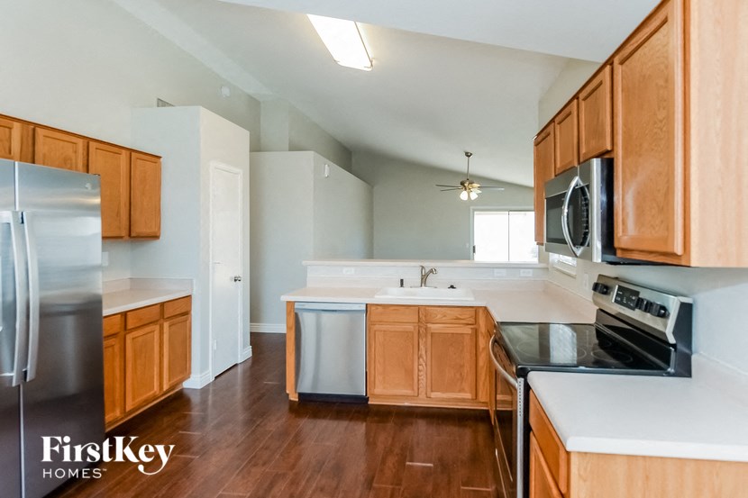 an empty kitchen with wooden cabinets and stainless steel appliances