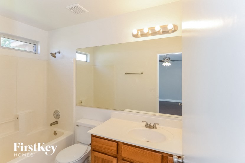 a bathroom with a sink toilet and a mirror