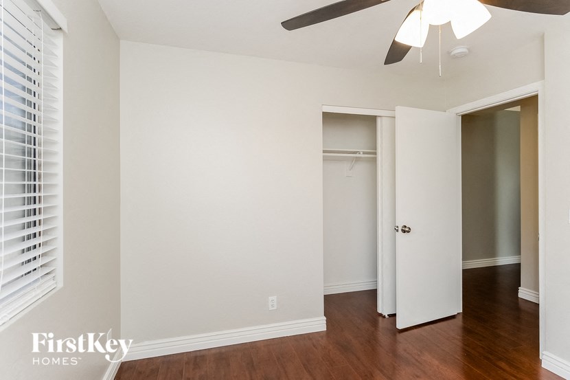 a bedroom with a closet and a ceiling fan