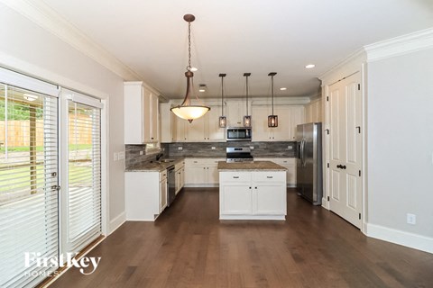 a large kitchen with white cabinets and stainless steel appliances
