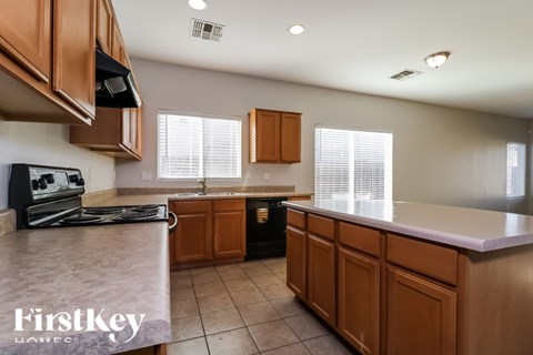 A kitchen with brown cabinets and a black stove top oven.
