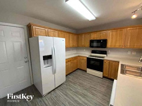 A kitchen with wooden cabinets and a white refrigerator.