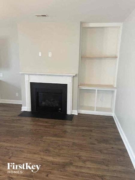 a living room with a fireplace and white shelves