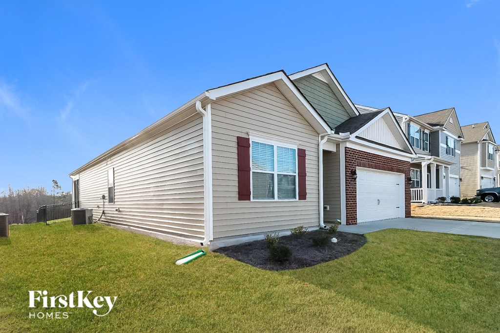 A house with a red window and a garage door is for sale.