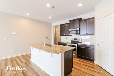 A kitchen with a white island and black appliances.