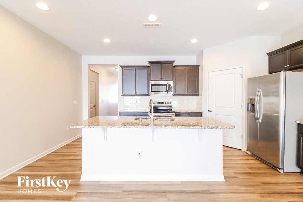 A kitchen with a white island and stainless steel appliances.