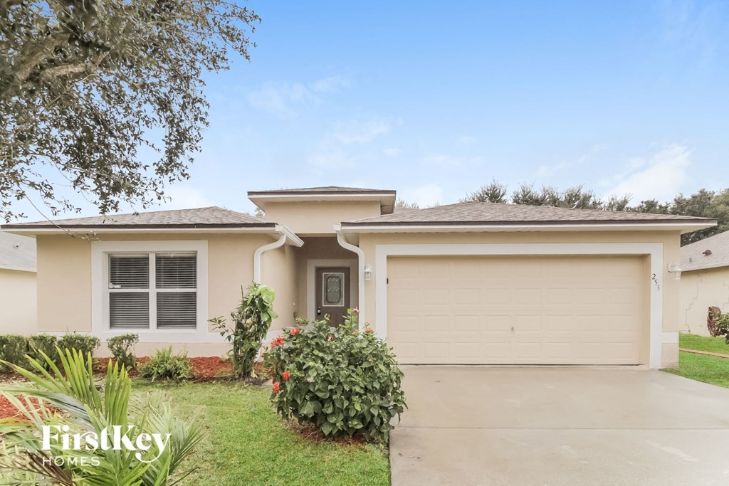 a beige house with a driveway and a garage door
