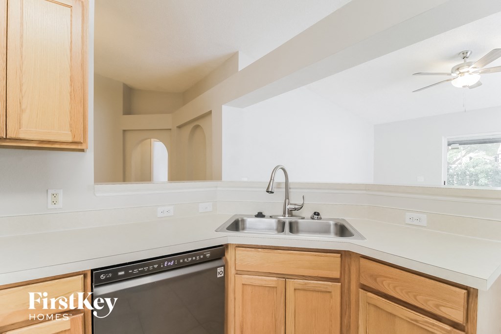 a kitchen with wooden cabinets and a sink and a dishwasher
