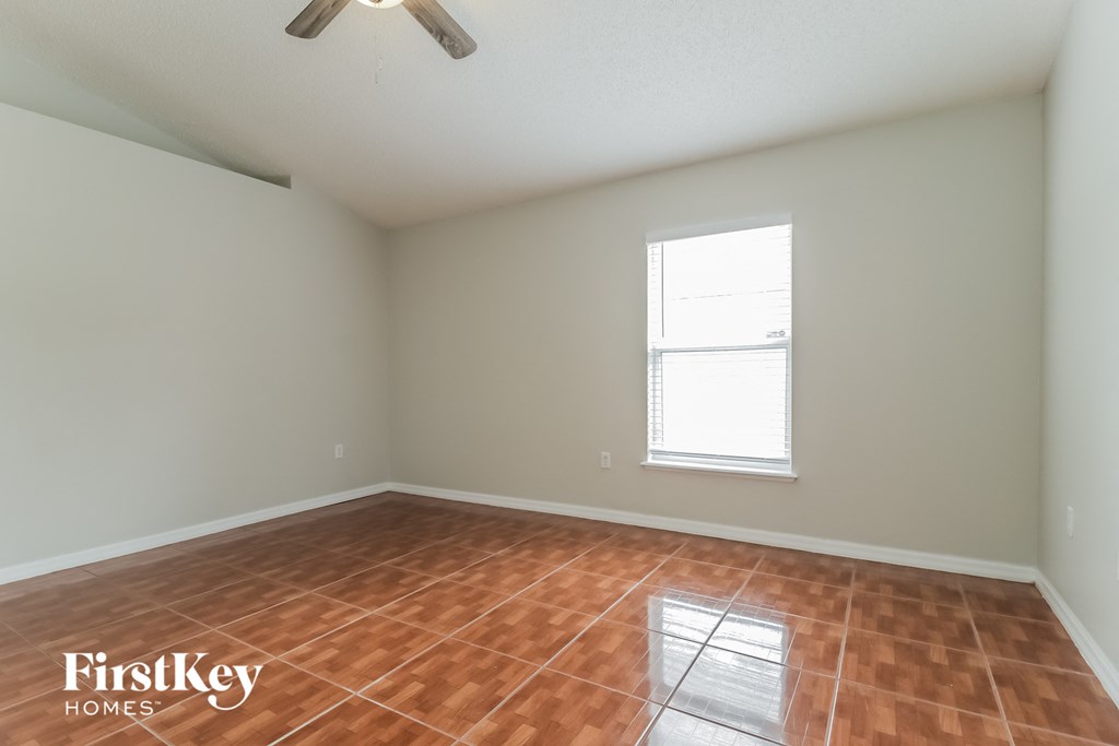 the living room with wood floors and a window