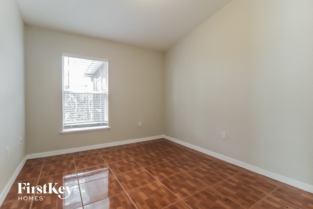 an empty room with wooden floors and a window