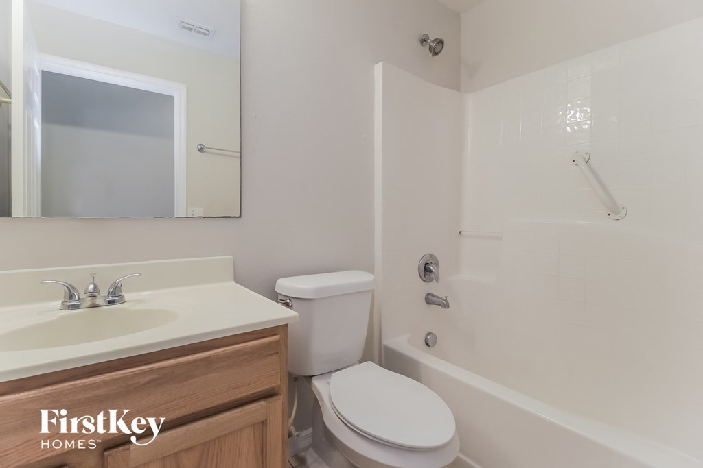 a bathroom with a toilet sink and shower and a mirror