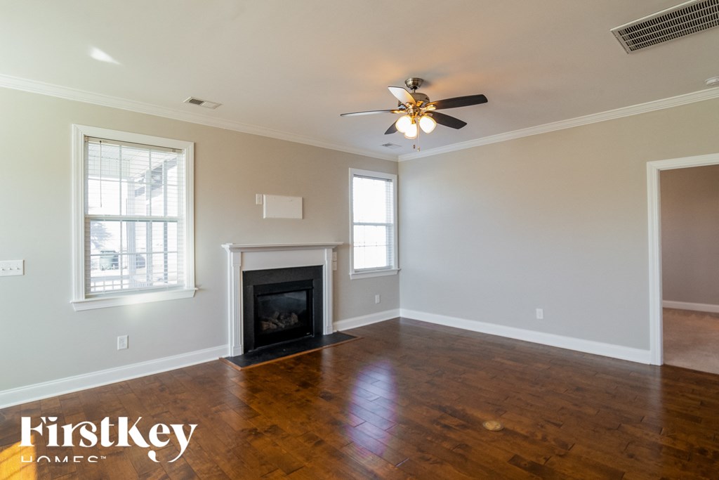 A spacious room with a fireplace and a ceiling fan.