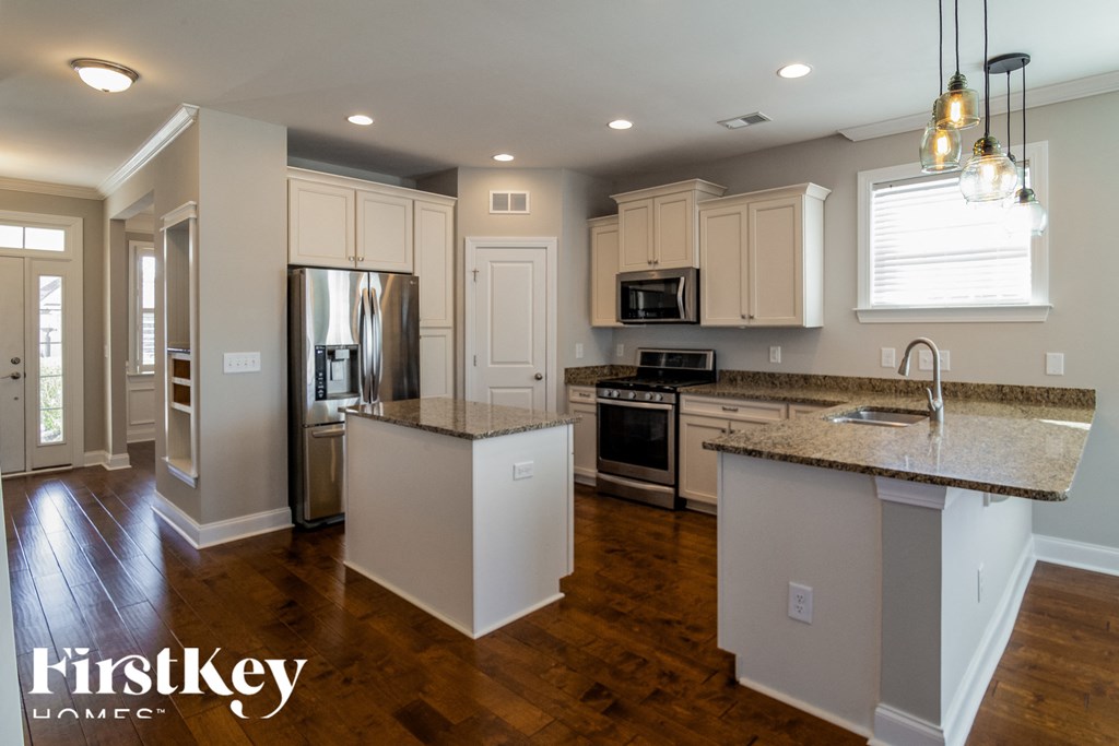 A kitchen with a granite countertop and a refrigerator.