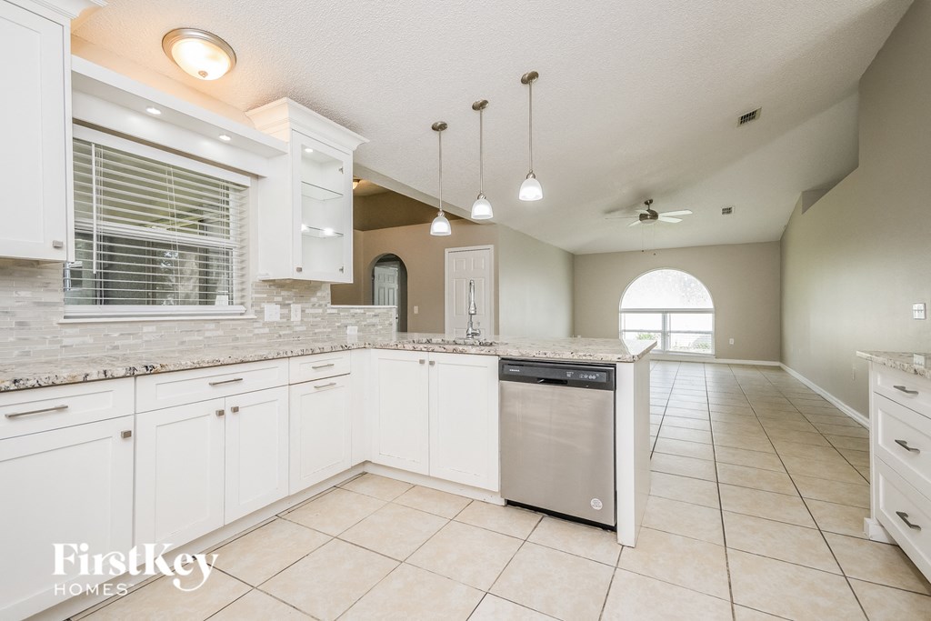 a large kitchen with white cabinets and a stainless steel dishwasher