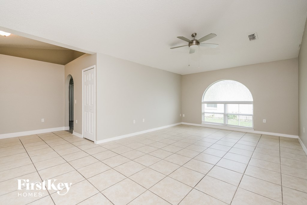 an empty living room with a ceiling fan