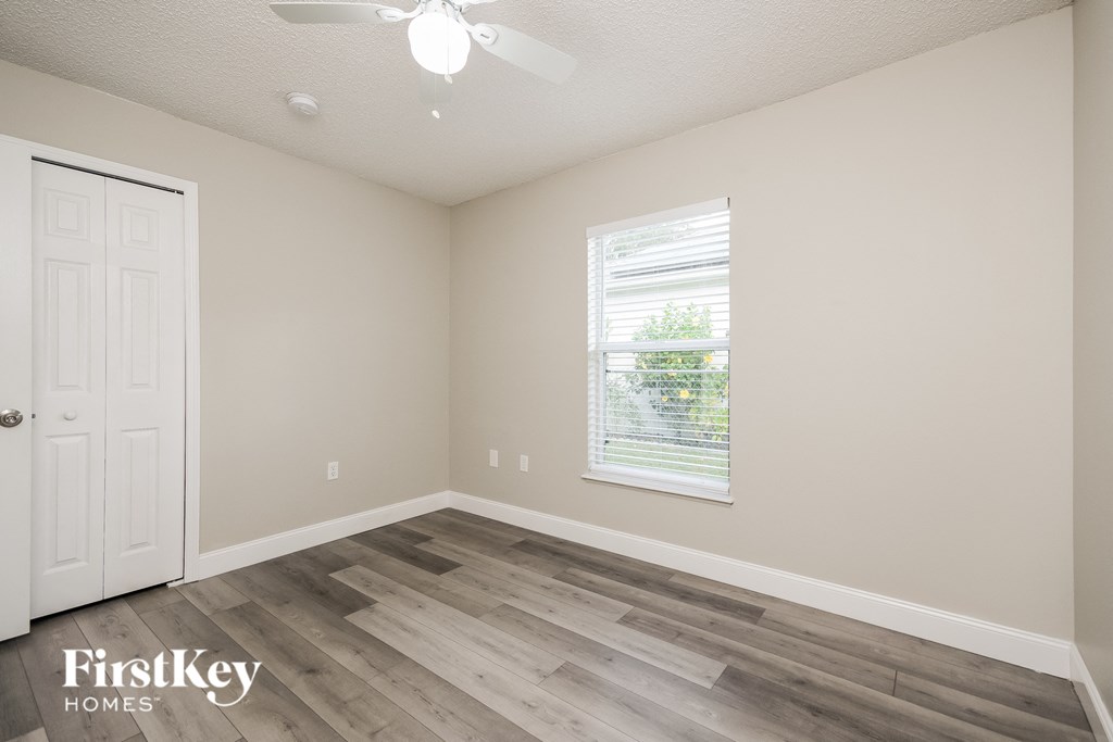 a bedroom with wood floors and a white door