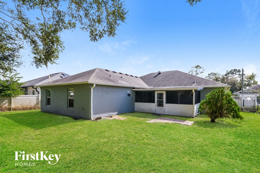 a white house with a yard and a tree