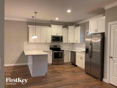 a kitchen with white cabinets and stainless steel appliances