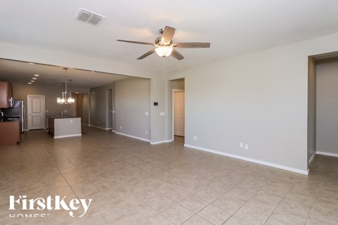 A spacious room with a ceiling fan and lighting fixtures.