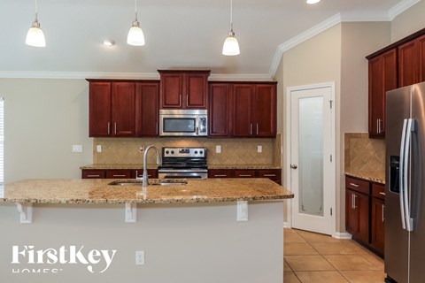 a kitchen with granite counter tops and wooden cabinets