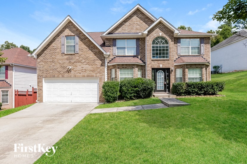 a brick house with a white garage door and a lawn