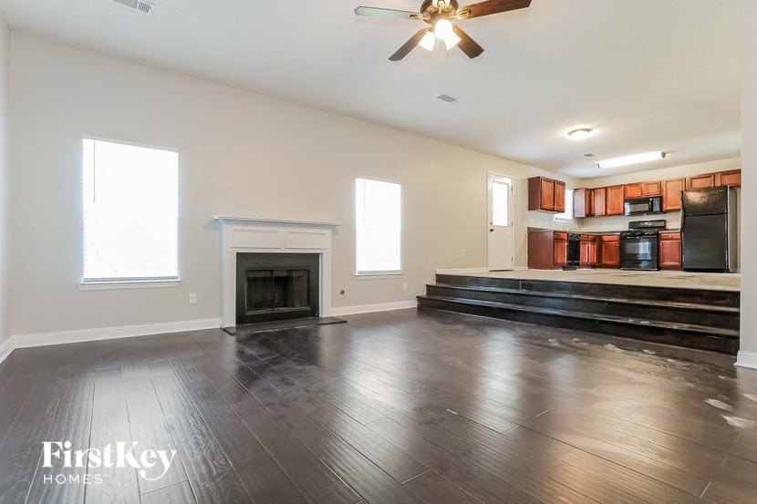 a empty living room with a fireplace and wooden floors