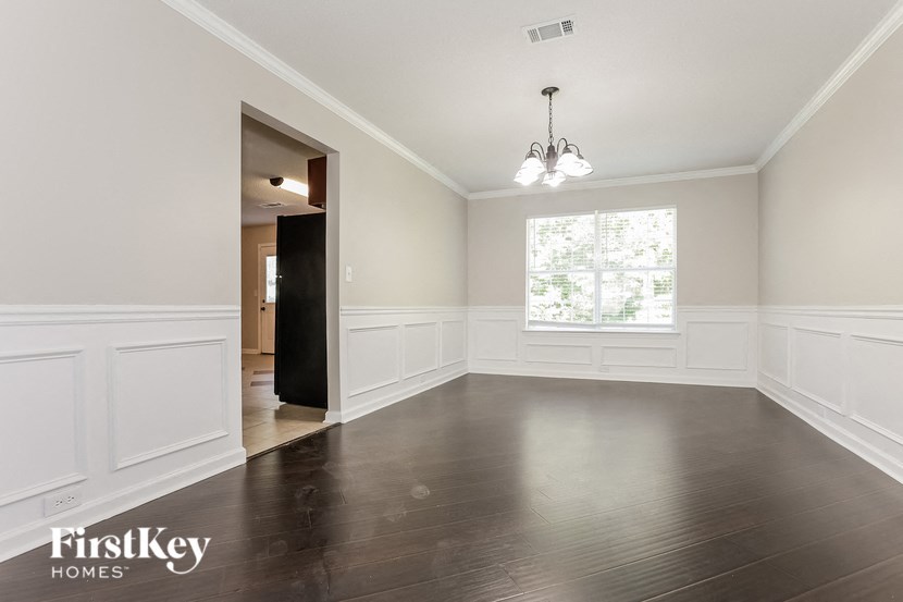 an empty living room with wood flooring and a window