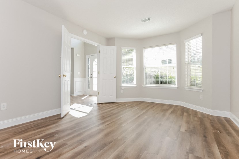an empty living room with white walls and wood floors
