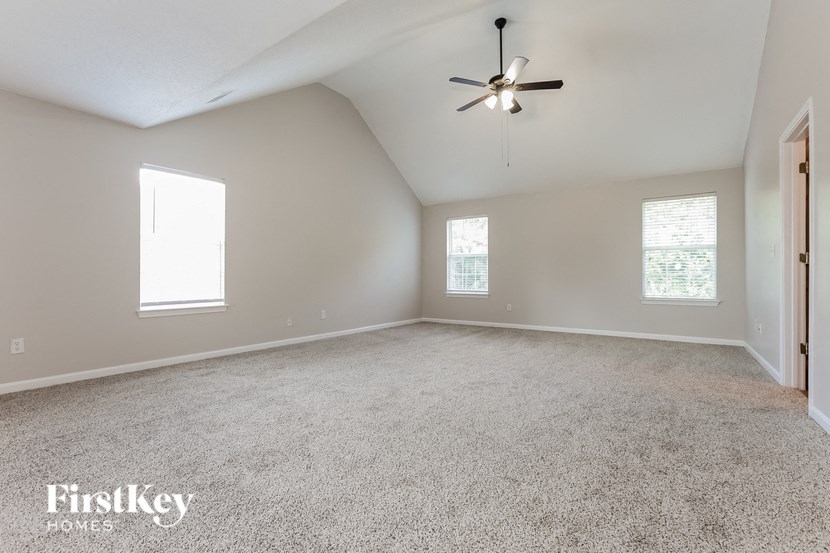 an empty living room with a ceiling fan