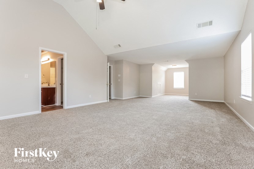 an empty living room with white walls and carpet