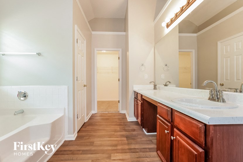 a bathroom with two sinks and a tub and a mirror