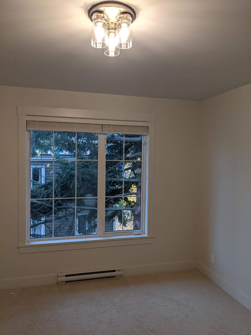 a bedroom with a large window and a chandelier