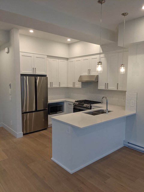 a kitchen with white cabinets and a stainless steel refrigerator