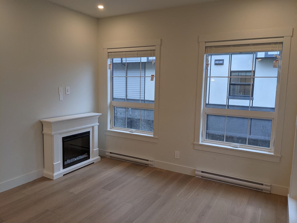 a living room with a fireplace and two windows