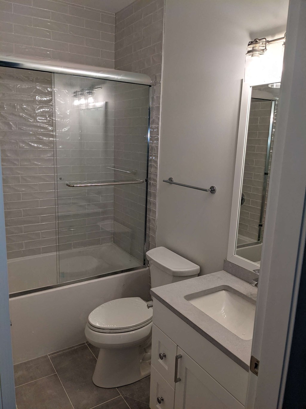 a white bathroom with a shower toilet and sink