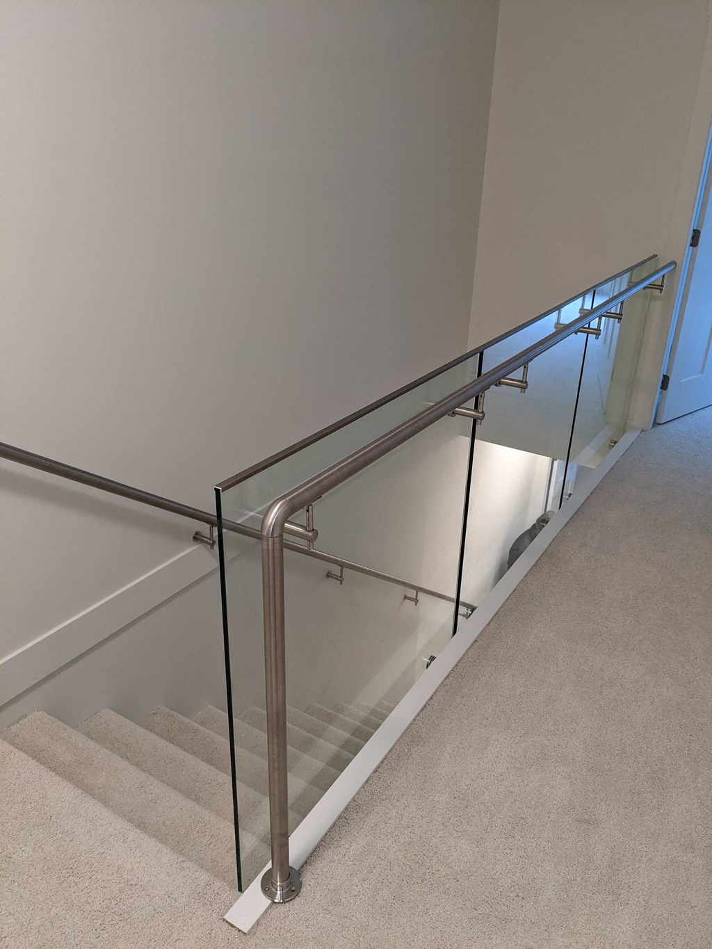 a view of a stairwell with stainless steel railing and white stairs