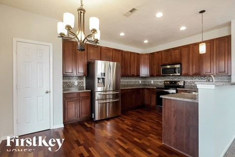 A kitchen with wooden cabinets and a stainless steel refrigerator.