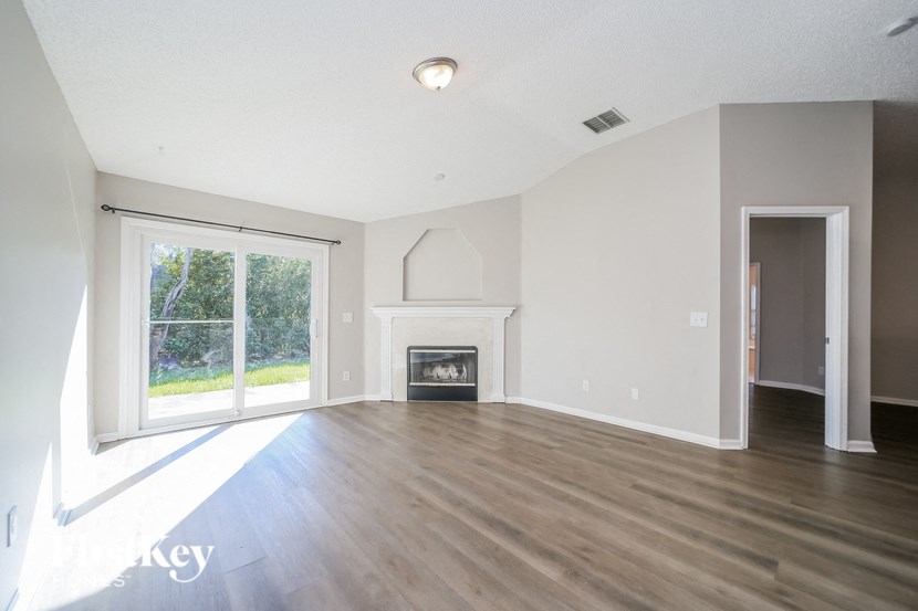 an empty living room with a fireplace and a window