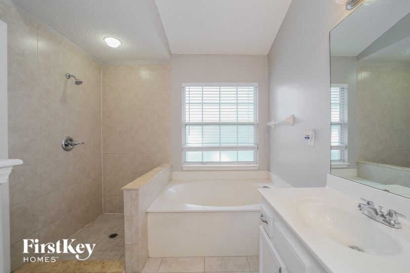 a bathroom with a tub and a sink and a mirror