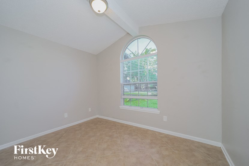 an empty living room with an arched window