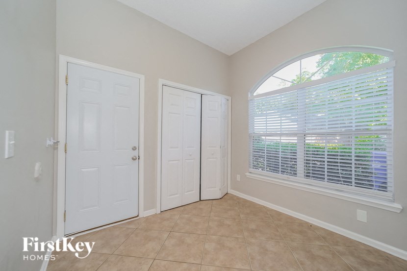 an empty bedroom with a large window and two doors