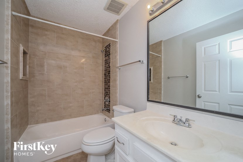 a bathroom with a sink toilet and a mirror