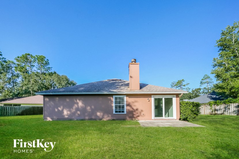 a small pink house in a grassy yard