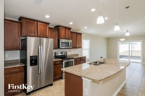 a kitchen with a granite counter top and a stainless steel refrigerator