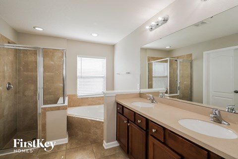 a bathroom with two sinks and a shower and a tub