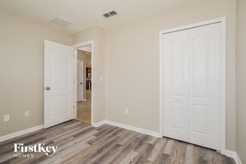 a bedroom with two closets and a door to a hallway