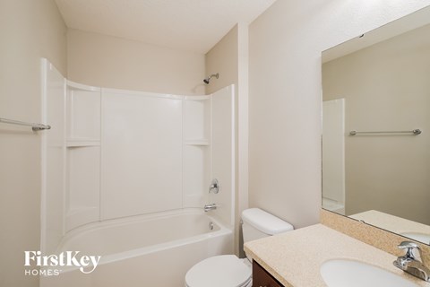 a bathroom with a shower toilet and sink and a mirror
