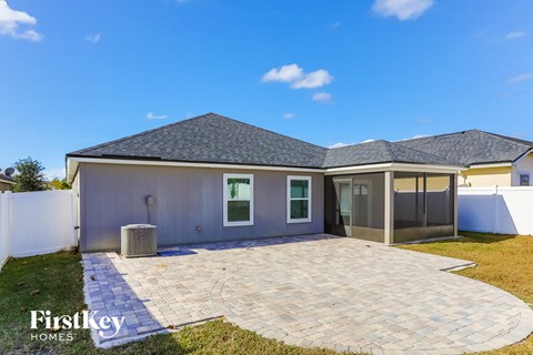 a backyard patio with a house and a blue sky